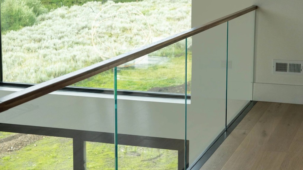 Modern interior glass railing with wood handrail and clear panels